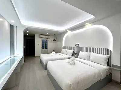 a hotel room with two beds with white pillows at DiscoveryHome2 at Pratunammarket in Bangkok
