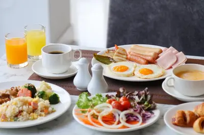 a table with plates of breakfast foods and drinks at Shewin de Bangkok in Ban Bang Bamru