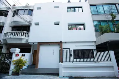 a white building with a door in front of it at Dado9home in Khlong Toei