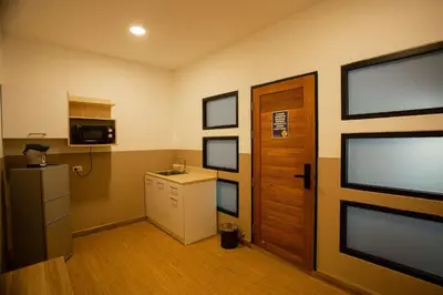 a small kitchen with a refrigerator and a door at Dado9home in Khlong Toei