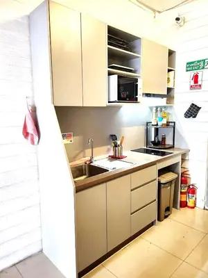 a kitchen with white cabinets and a sink at Back Home Backpackers Hostel in Bangkok