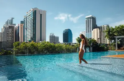 a woman in a swimming pool with a city in the background at Radisson Blu Plaza Bangkok in Bangkok