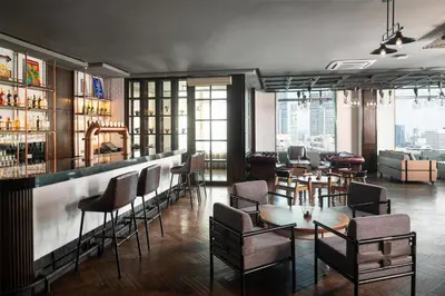 a restaurant with a bar and tables and chairs at Radisson Blu Plaza Bangkok in Bangkok