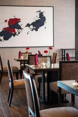 a restaurant with tables and chairs with flowers on them at Radisson Blu Plaza Bangkok in Bangkok