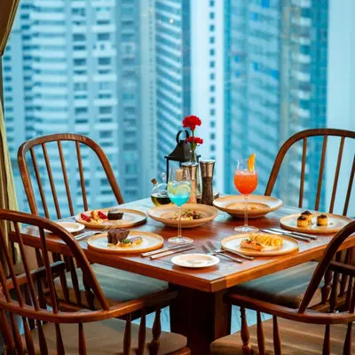 a wooden table with plates of food and drinks on it at Radisson Blu Plaza Bangkok in Bangkok