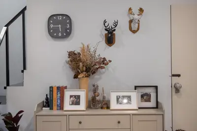 a shelf with three pictures and a clock on a wall at Spacious Haven Chatuchak Market 5BR 10 Sleeps RB1 in Ban Zong Katiam