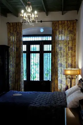 a bedroom with a bed and a large window at The Bhuthorn Bed & Breakfast in Bangkok