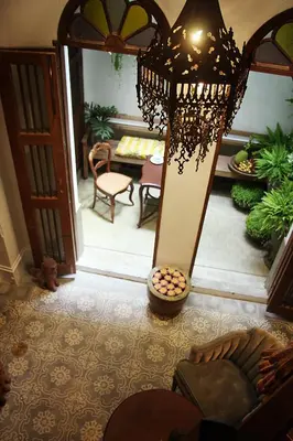 a chandelier is hanging in a living room at The Bhuthorn Bed & Breakfast in Bangkok
