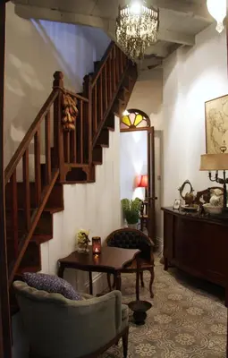 a living room with a staircase and a table at The Bhuthorn Bed & Breakfast in Bangkok
