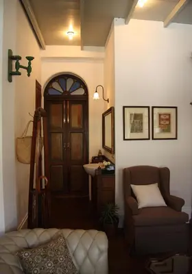 a living room with a door and a couch and a sink at The Bhuthorn Bed & Breakfast in Bangkok