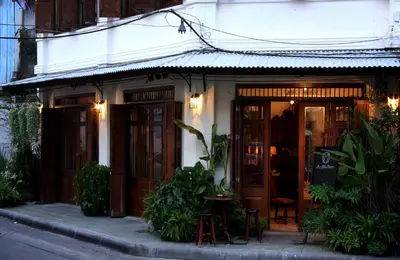 a building with a table and chairs in front of it at The Bhuthorn Bed & Breakfast in Bangkok