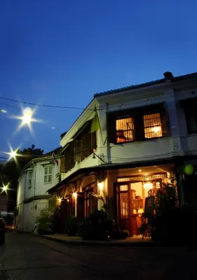 an old house with its lights on at night at The Bhuthorn Bed & Breakfast in Bangkok