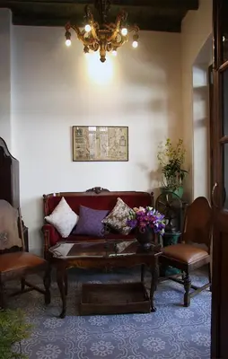 a living room with a couch and two chairs at The Bhuthorn Bed & Breakfast in Bangkok