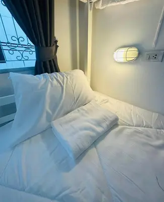 a white bed with a pillow on top of it at PICCOLO SUKHUMVIT HOSTEL- Self check-in after 6 pm in Bangkok