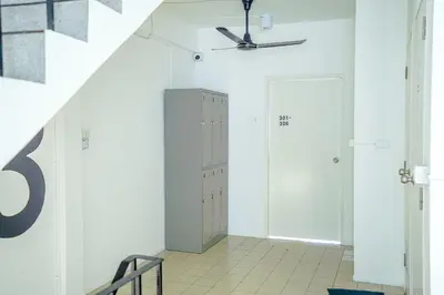 a hallway with white walls and a ceiling fan at PICCOLO SUKHUMVIT HOSTEL- Self check-in after 6 pm in Bangkok