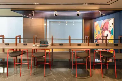 a conference room with a large wooden table and stools at Lumen Bangkok Udomsuk Station in Bangkok