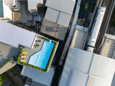 an overhead view of a swimming pool on top of buildings at Lumen Bangkok Udomsuk Station in Bangkok