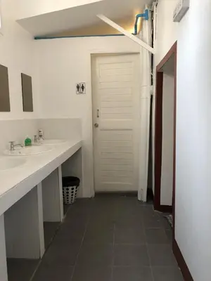 a bathroom with two sinks and a white door at PLOY Hostel in Bangkok
