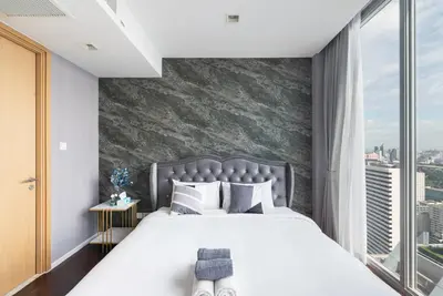 a bedroom with a large bed and a large window at The Pinnacle Sukhumvit 11 by LeFoyer in Bangkok