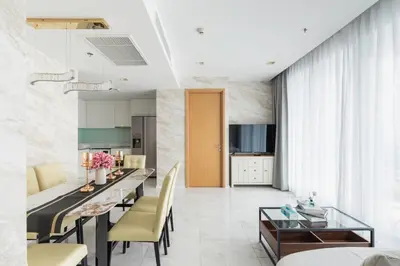 a kitchen and living room with a dining table and chairs at The Pinnacle Sukhumvit 11 by LeFoyer in Bangkok