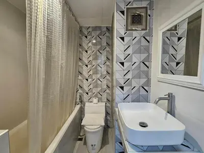 a bathroom with a white sink and a toilet at Crown BTS Nana Hotel in Bangkok