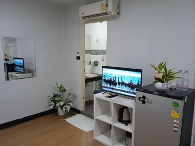 a living room with a computer on a refrigerator at NK Guesthouse 1 in Khlong Toei