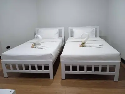 two white beds with swans on them in a room at NK Guesthouse 1 in Khlong Toei