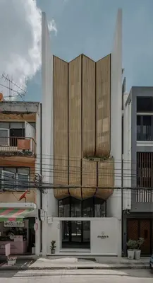 a building with wooden panels on the side of it at Double B Hostel in Bangkok