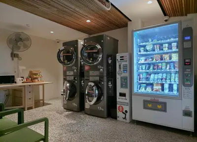 two washing machines in a room with a refrigerator at Double B Hostel in Bangkok