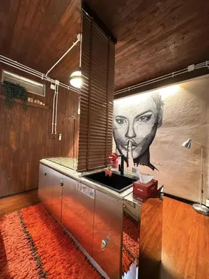 a kitchen with a painting of a face on the wall at New York Loft & Japanese Magic by V4SKIN in Bangkok