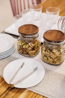a table with a white plate and jars of nuts at Casa Luna in Bangkok