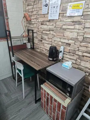 a microwave sitting on a table next to a brick wall at 206 Lovely Room with cool fan with full amenities & Free Wi-Fi in Bangkok