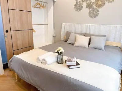 a bed with towels and a vase of flowers on it at Unwind in oldtown, private floor, near Grand Palace in Bangkok