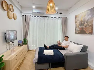 a man sitting on a bed reading a book at Unwind in oldtown, private floor, near Grand Palace in Bangkok