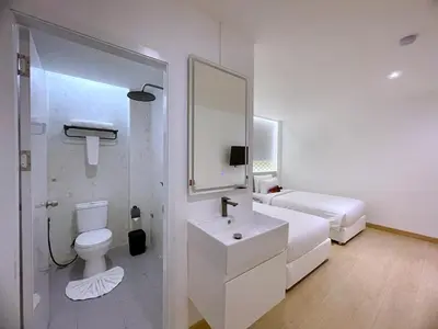 a white bathroom with a toilet and a sink at Arawana Express Sukhumvit 22 in Bangkok