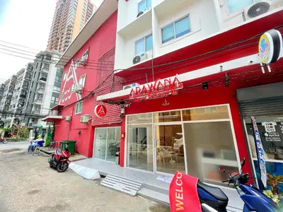 a red building with a restaurant with motorcycles parked outside at Arawana Express Sukhumvit 22 in Bangkok