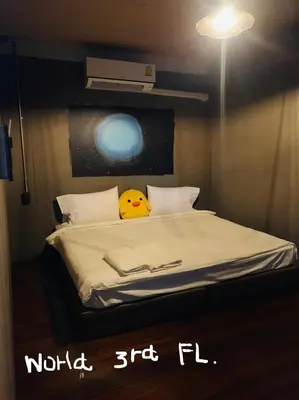 a room with a bed with a yellow pillow on it at Enterspace Chinatown in Khlong San