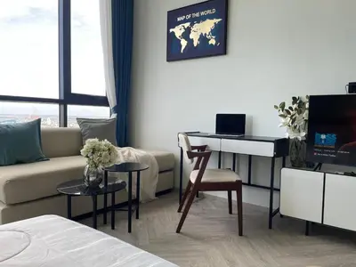 a living room with a couch and a desk with a television at Luxury River View in Bangkok