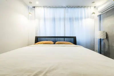 a bedroom with a large white bed with a window at Inner Old Town 196 Chic Guesthouse - self check in in Bangkok