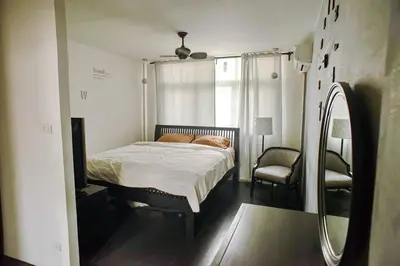 a bedroom with a bed and a chair and a mirror at Inner Old Town 196 Chic Guesthouse - self check in in Bangkok