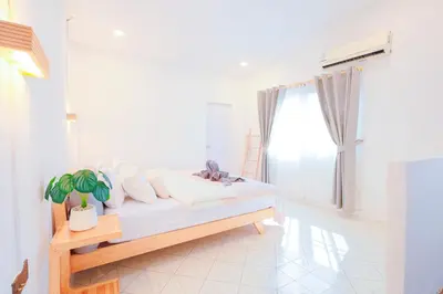 a white room with a bed and a window at Ratchada Retreat Villa 2 in Bangkok