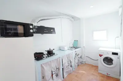 a kitchen with a stove and a washing machine at Ratchada Retreat Villa 2 in Bangkok