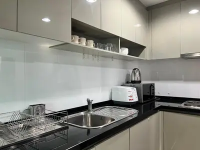 a kitchen with a sink and a microwave at Rama9 Luxe Suites in Bangkok