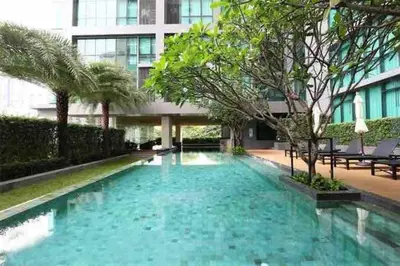 a swimming pool in front of a building at Luxurious in Prime Area Bangkok (PickupService) in Bangkok