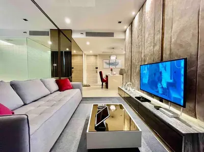 a living room with a couch and a flat screen tv at Luxurious in Prime Area Bangkok (PickupService) in Bangkok