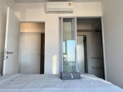 a bedroom with a bed and a large mirror at Ramkhamhaeng Condo in Bangkok