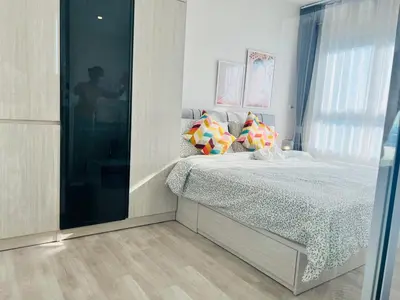 a bedroom with a bed and a large window at Ramkhamhaeng Condo in Bangkok