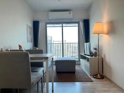 a living room with a desk and a balcony at Ramkhamhaeng Condo in Bangkok