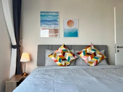 a bedroom with a bed with two pillows on it at Ramkhamhaeng Condo in Bangkok