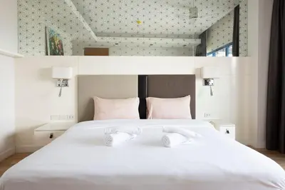 a bedroom with a white bed with two towels on it at M Estate Private Residence 3BR, Heart of Bangkok in Bangkok